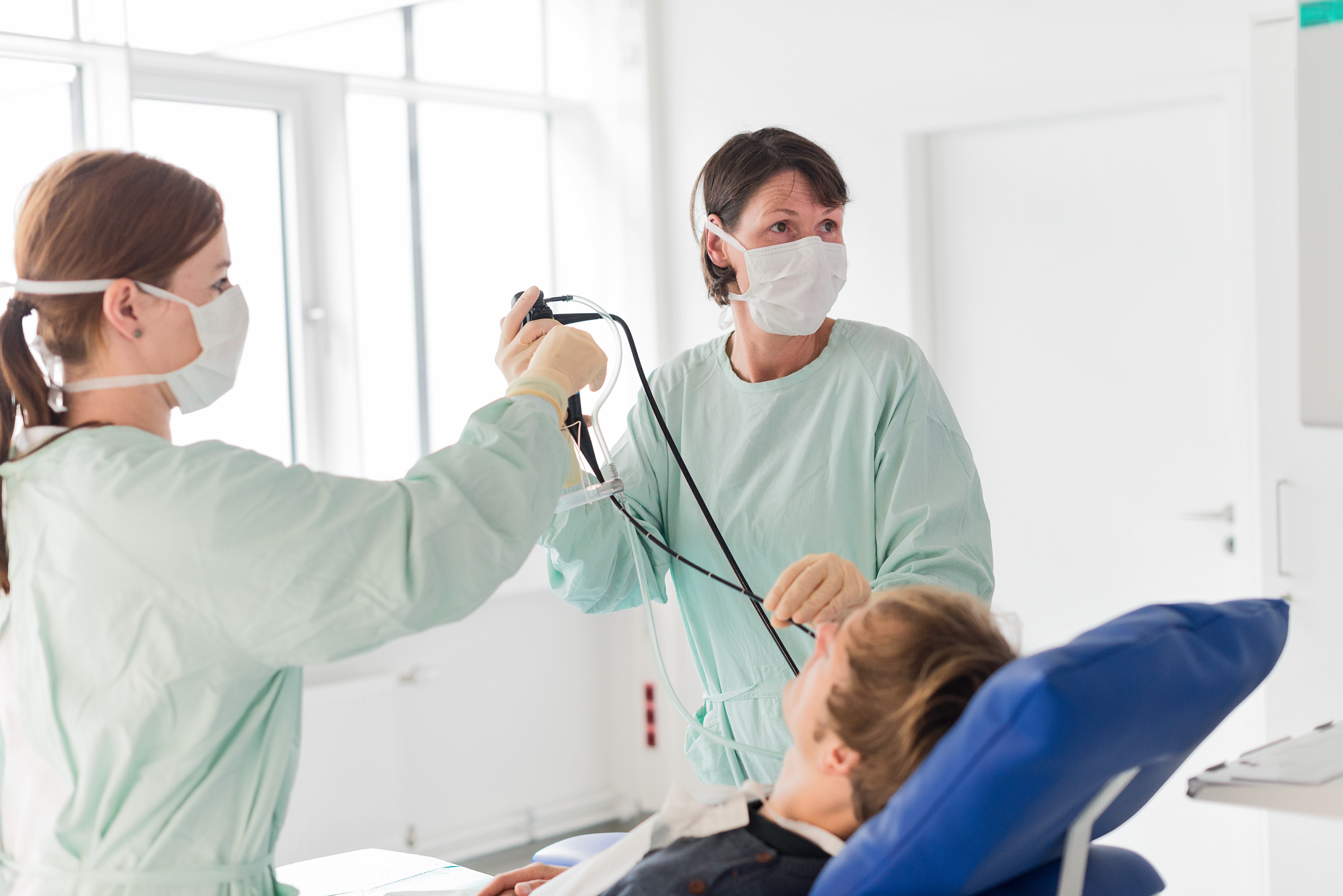 Ärztin und Arzthelferin bei der Bronchoskopie eines Patienten.