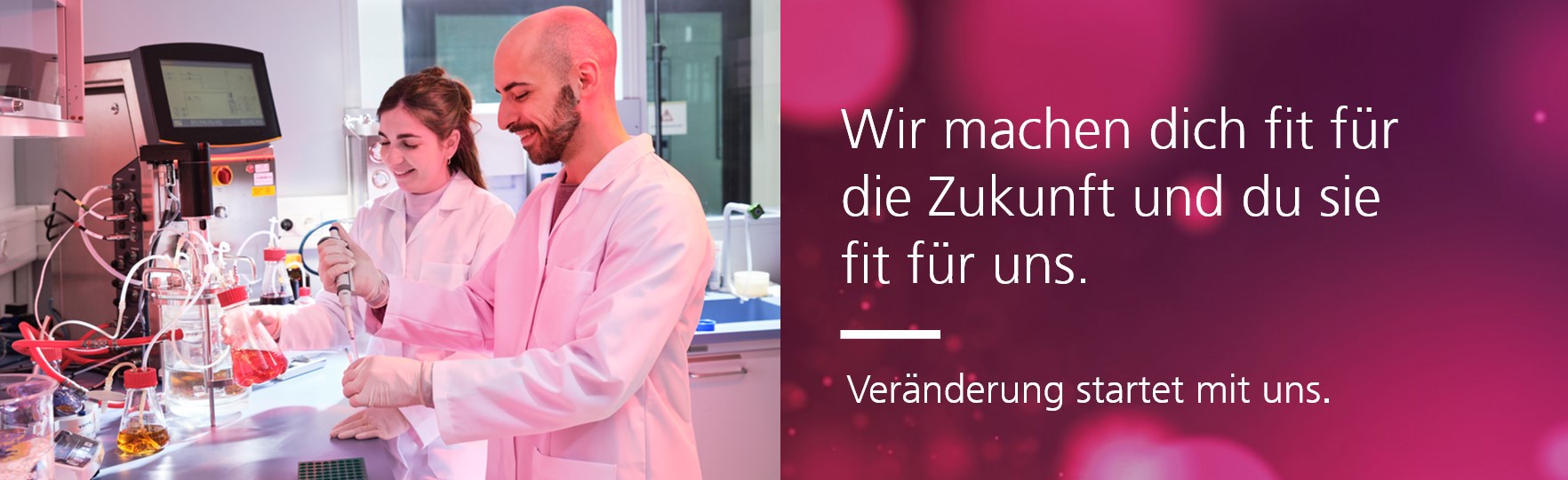 Zwei Personen in weißen Laborkitteln arbeiten an Laborgeräten und Flüssigkeiten. Rechts daneben befindet sich ein Textfeld mit der Aufschrift: „Wir machen dich fit für die Zukunft und du sie fit für uns. Veränderung startet mit uns.“ vor einem rötlich-violetten Hintergrund mit unscharfen Lichteffekten.