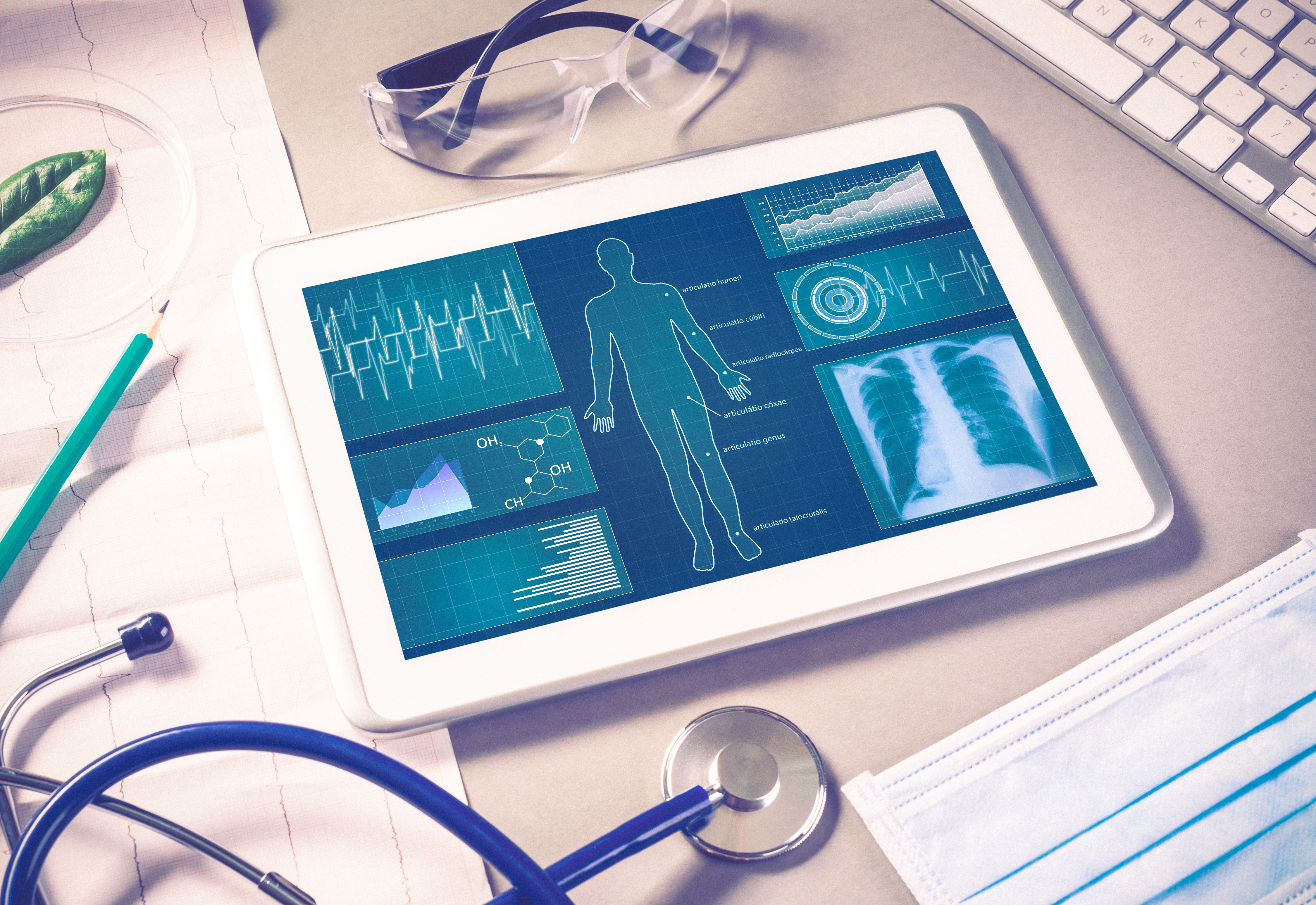 iPad with medical data; a stethoscope in the foreground.