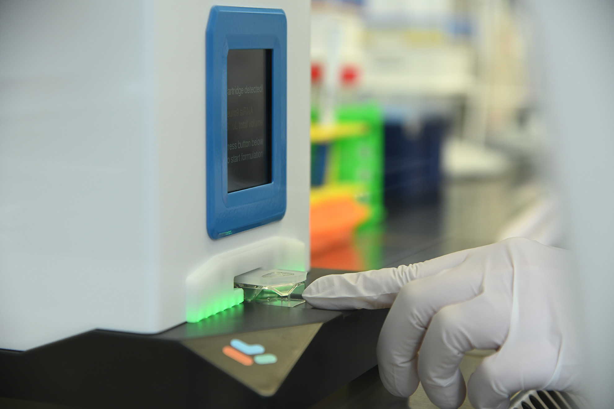 Index finger of a hand in a laboratory glove taps on a laboratory device.
