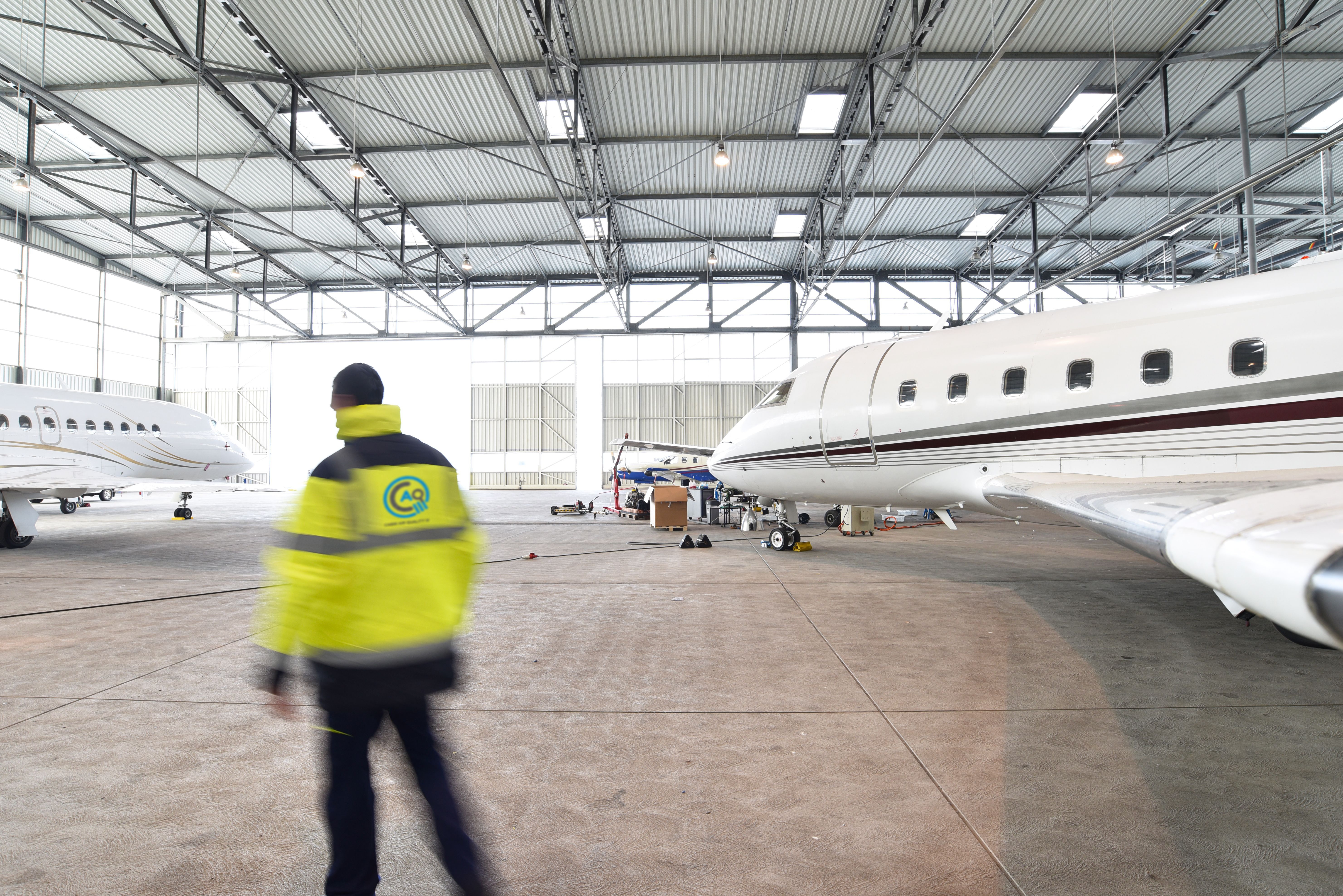 Airport worker standing in an aircraft hangar.