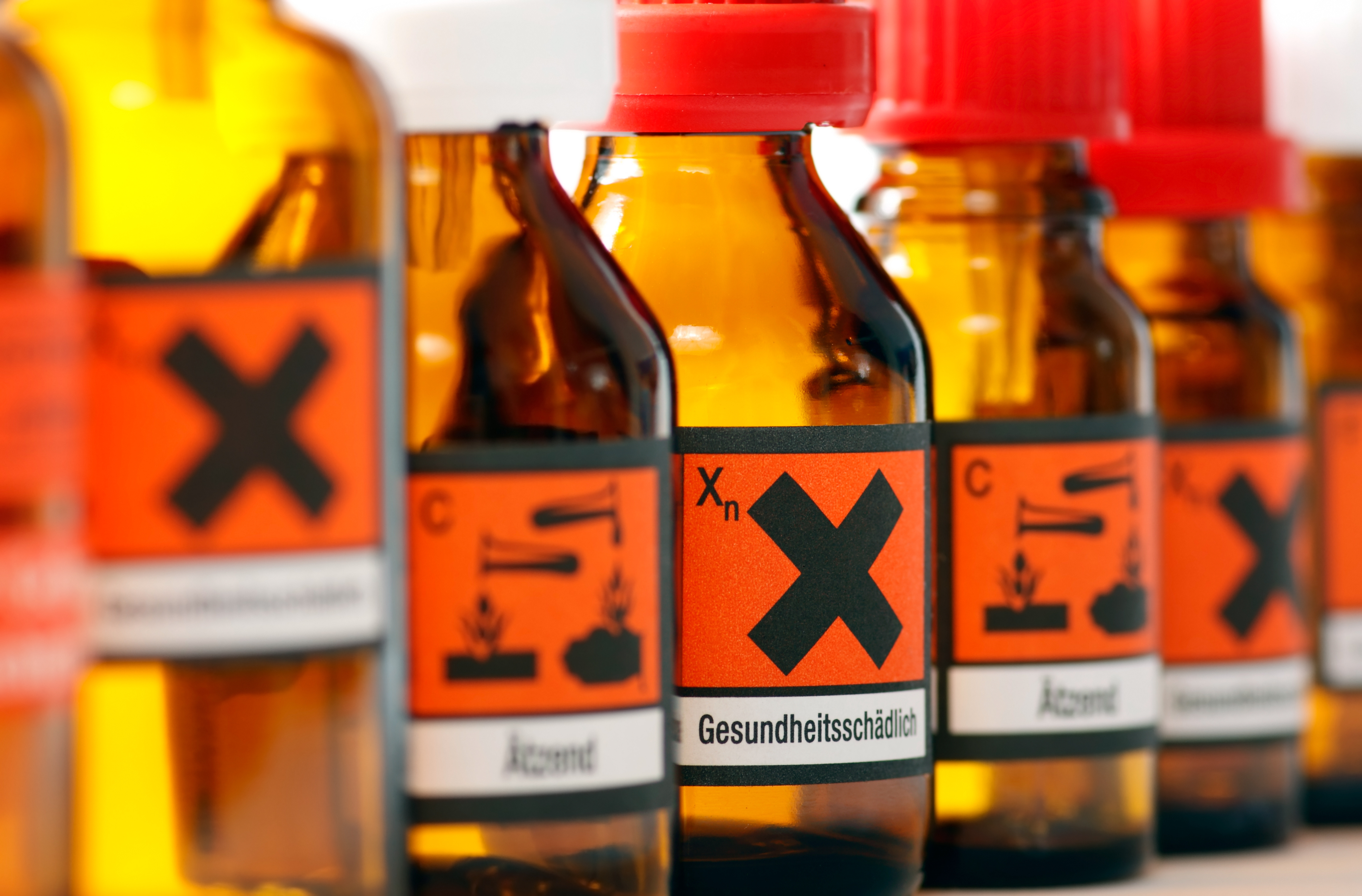 Gefahrstoffe Brown bottles labeled with hazardous material symbols.