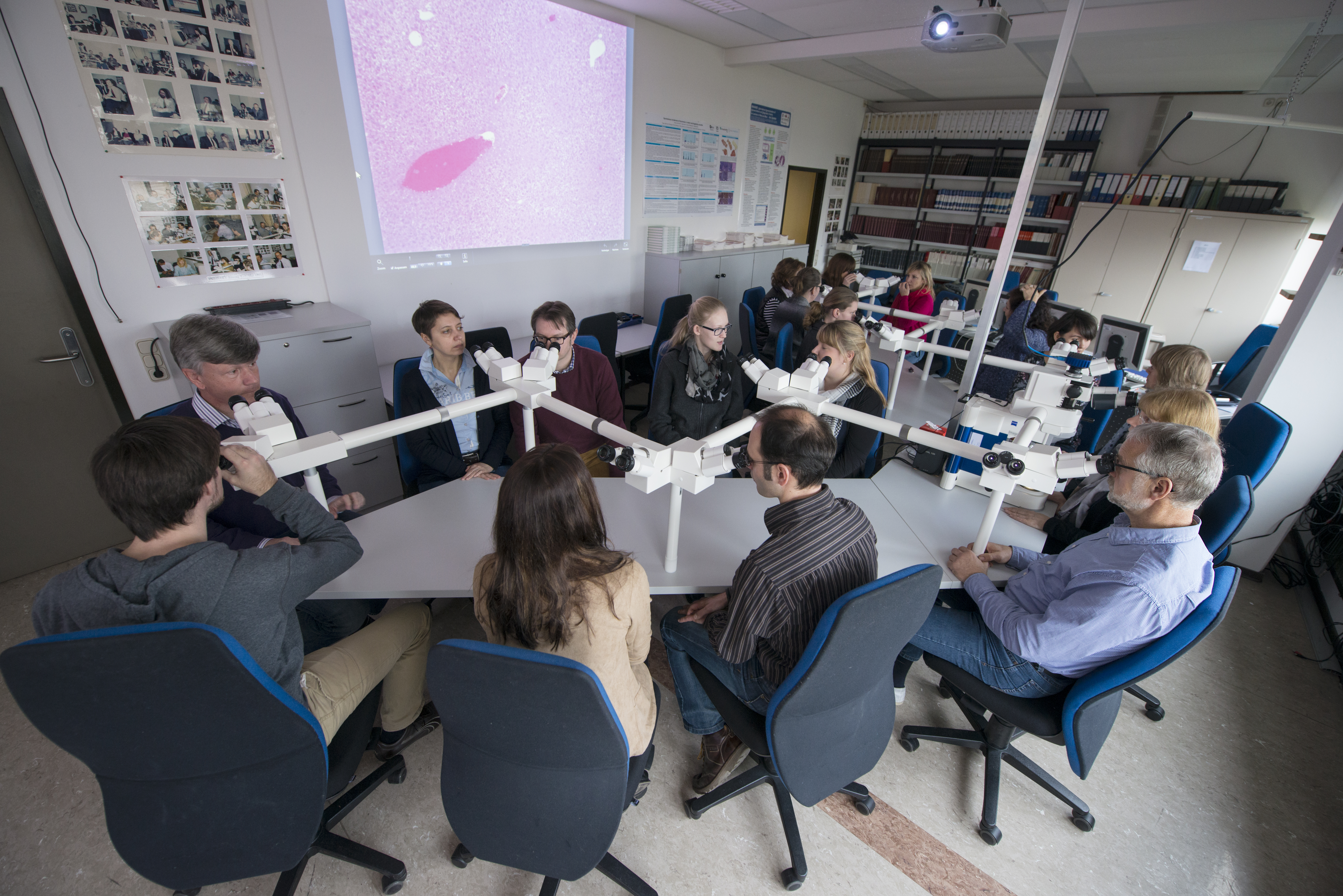 Researchers at a discussion microscope.